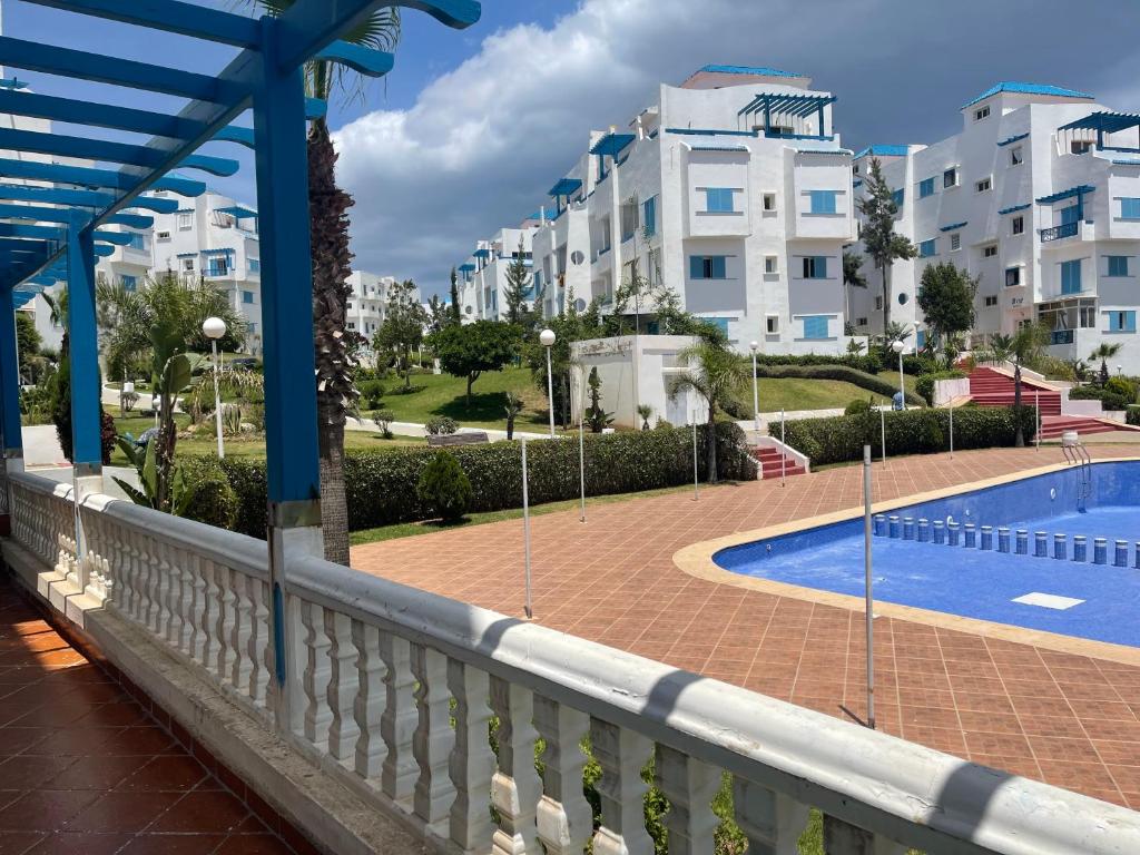 einen Balkon mit Pool und einigen Gebäuden in der Unterkunft Luxury apartment with swimming pool view in Marina Smir