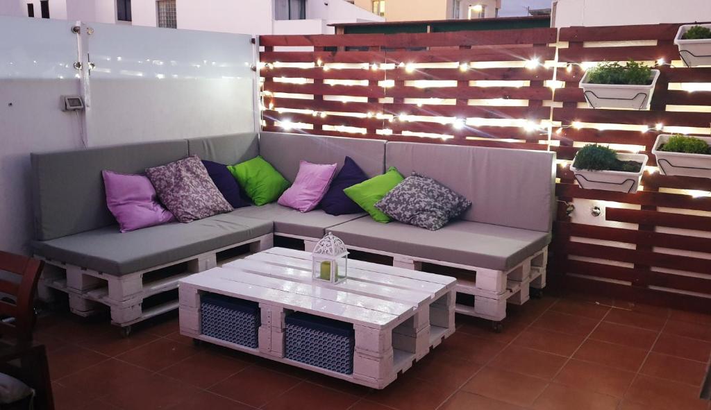 un patio con sofá, mesa y luces en Paradise room near the beach en Playa Honda