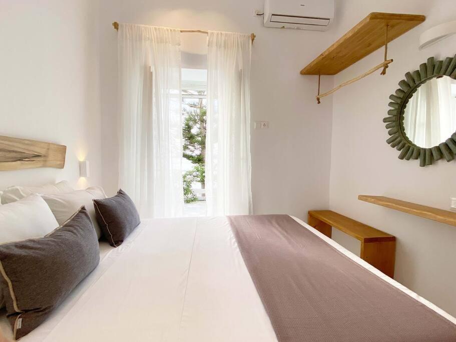 a large white bed in a room with a window at Lyra Seafront Apartment , Paroikia Town Center in Parikia