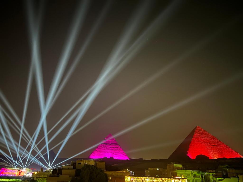 a view of the pyramids at night with red lights at Grand Pyramids Inn in Cairo