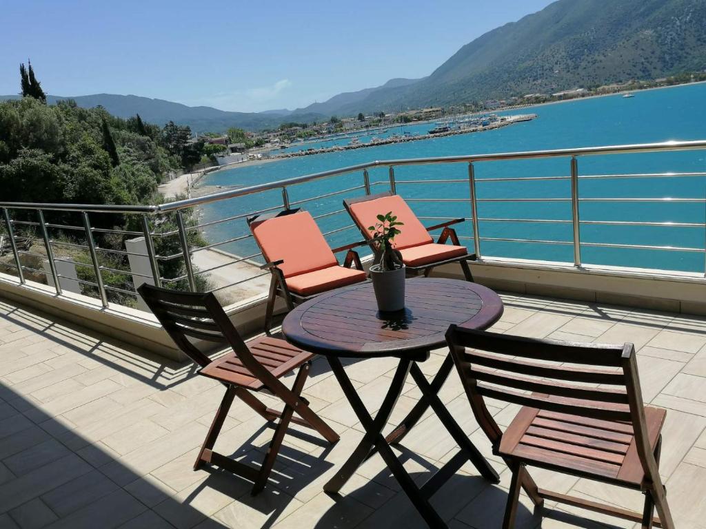 einen Tisch und Stühle auf einem Balkon mit Blick auf das Wasser in der Unterkunft Ocean views in Plataria