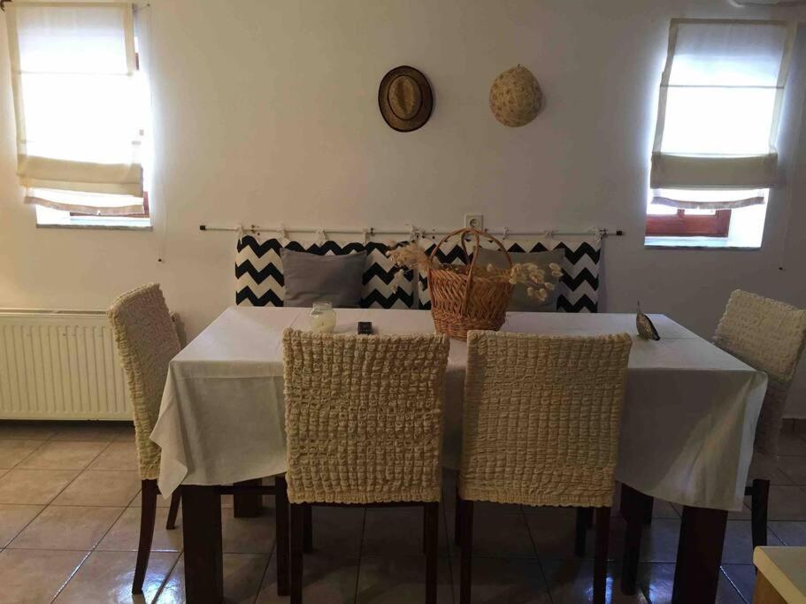 a dining room with a white table and chairs at All stone, everything.. in Areopoli