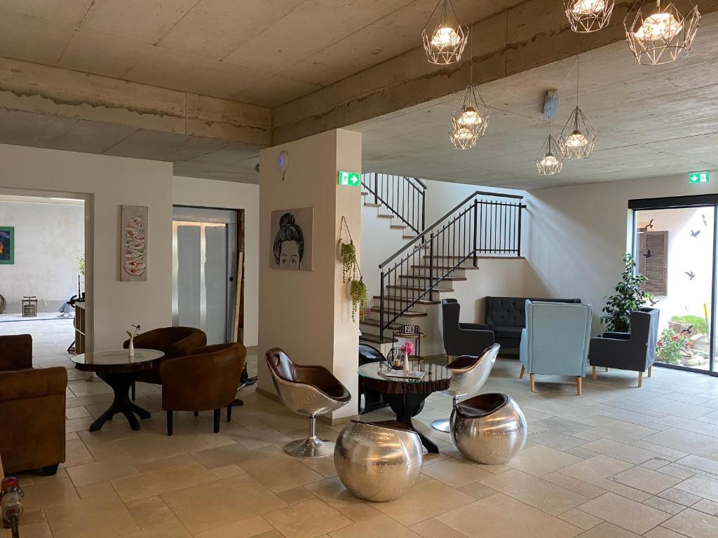 sala de estar con escalera, mesas y sillas en Stockers kleines Dorfhotel, en Deutsch Goritz