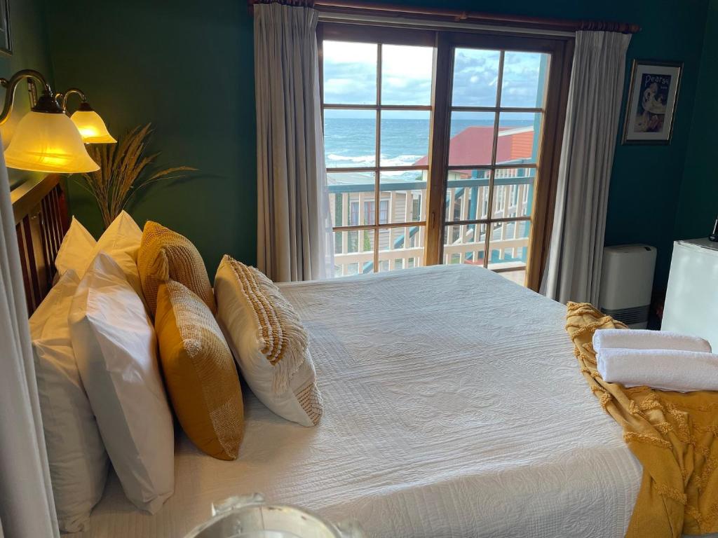 een slaapkamer met een bed en uitzicht op de oceaan bij Hanlon Guest House in Stanley