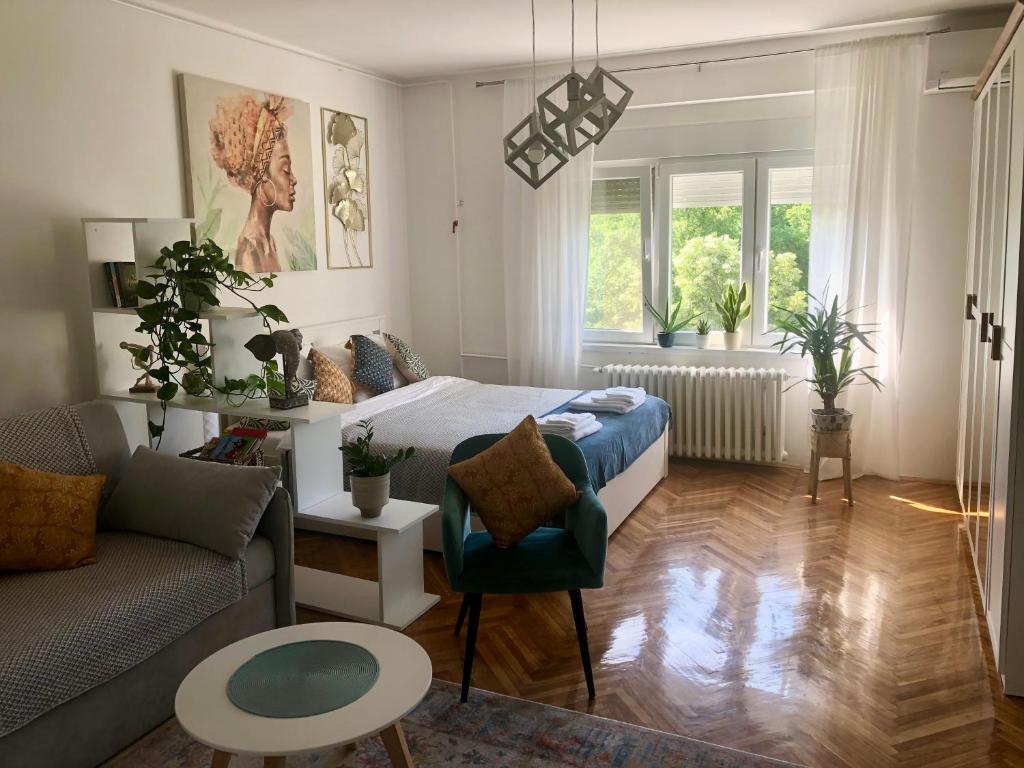 een woonkamer met een bed en een bank bij Casa Lusi in Novi Sad