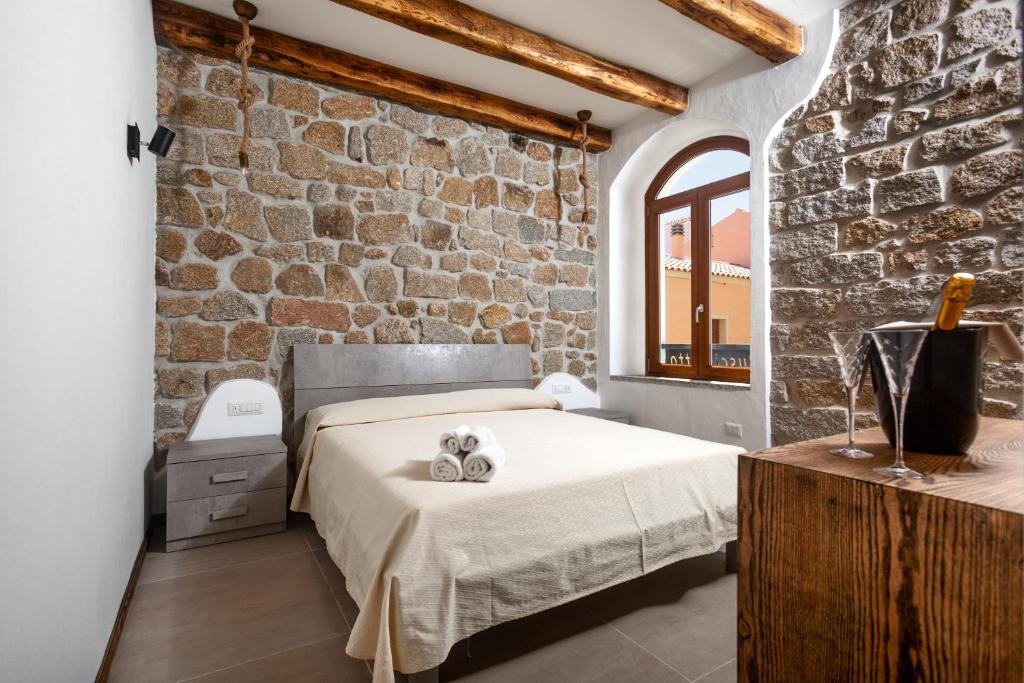 a bedroom with a bed and a brick wall at Il Busciolotto in Santa Teresa Gallura