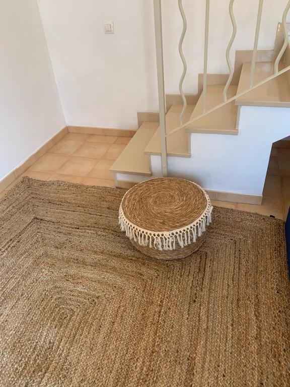 a rug on the floor in a room with a staircase at Es Cucó in Cala Galdana