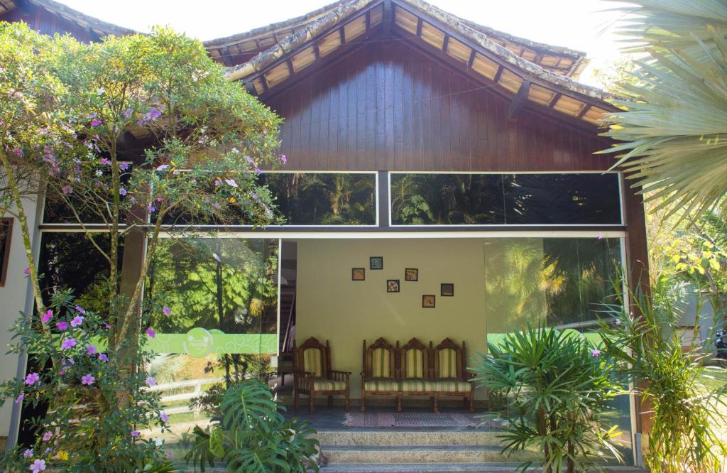 una casa con árboles y plantas delante de ella en Pousada Cascata, en Casimiro de Abreu