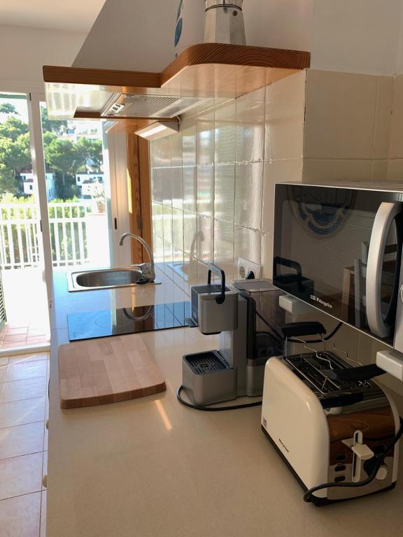 a kitchen with a toaster oven and a counter top at Es Cucó in Cala Galdana