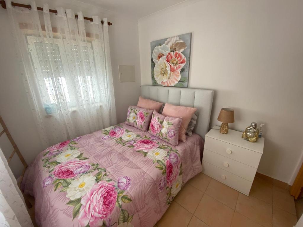 - une chambre avec un lit rose et des fleurs dans l'établissement Faneca Beach Room - Faneca Apartamentos, à Nazaré