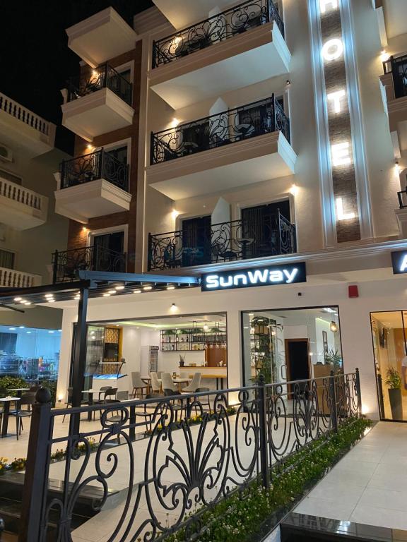 a view of a building with a sunway sign at night at Hotel Sunway in Ksamil