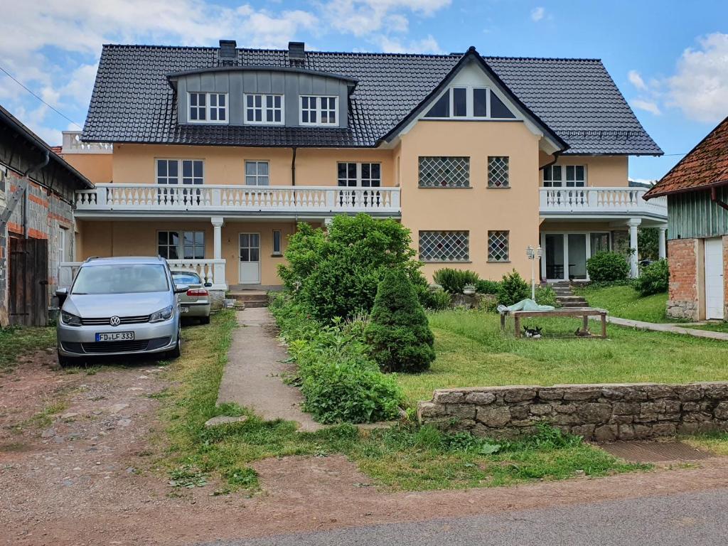 a house with a car parked in front of it at BIO-Bauernhof Rhön in Schleid