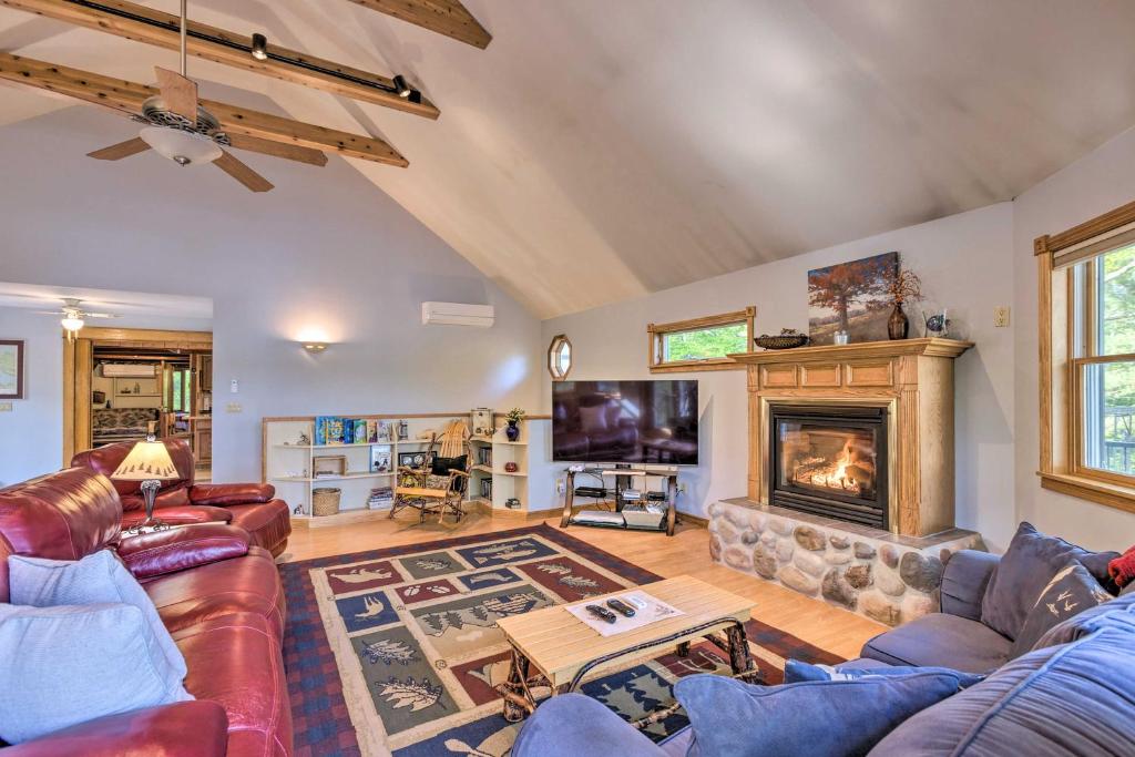 Hot Tub, Sauna, Fireplace, Dock! Lake Honor Cabin في Honor: غرفة معيشة مع كنب ومدفأة