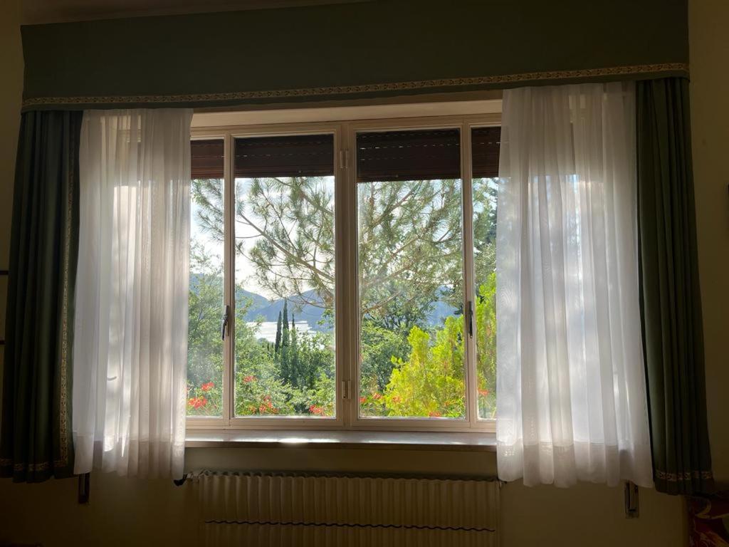 a window with white curtains in a room at Casetta Lake and Sun in Labro