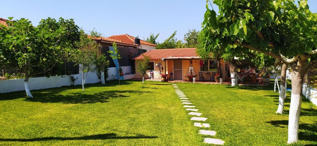 um quintal com árvores e uma casa em Amaryllis sweet home em Pirgos