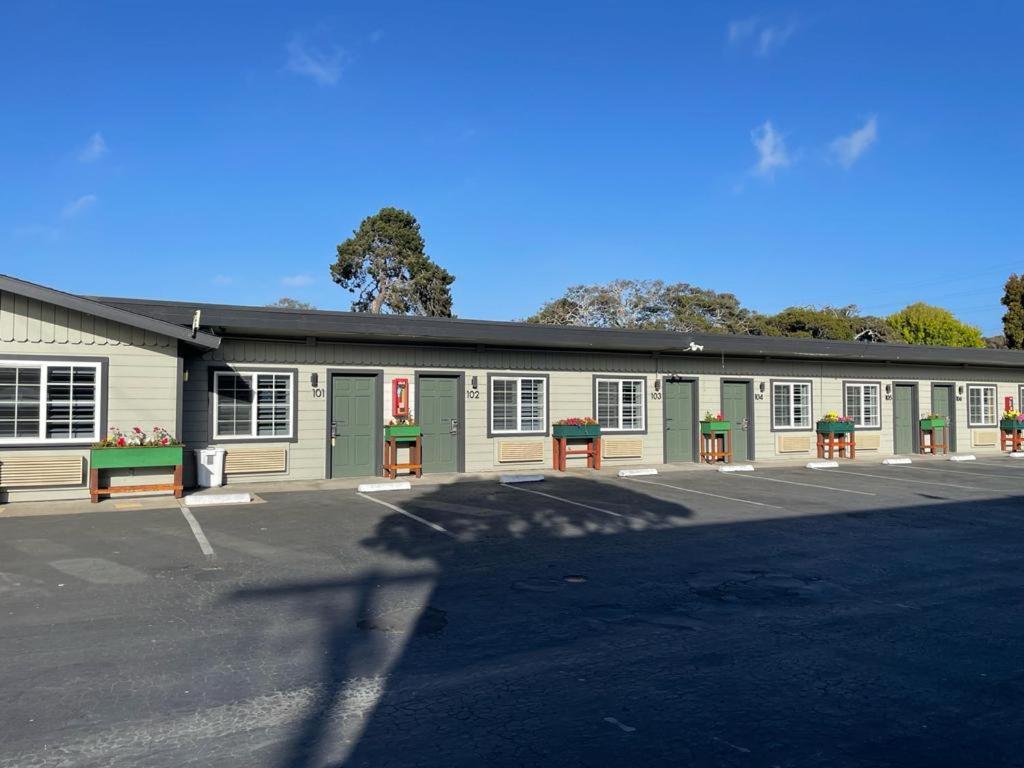 a building with green doors and a parking lot at The Fremont Inn in Monterey