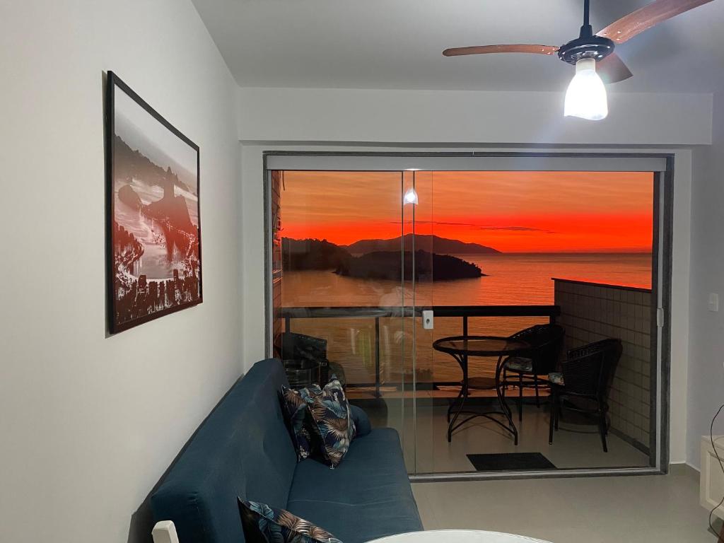 ein Wohnzimmer mit einer blauen Couch und Blick auf einen Tisch in der Unterkunft APARTAMENTO PORTO REAL RESORT VISTA ESPETACULAR 2 in Mangaratiba