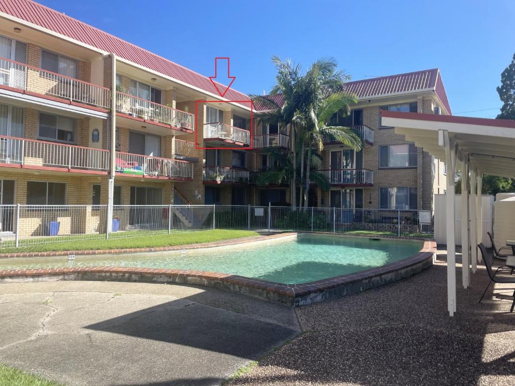 a swimming pool in front of a apartment building at Passage Breeze! in Bongaree