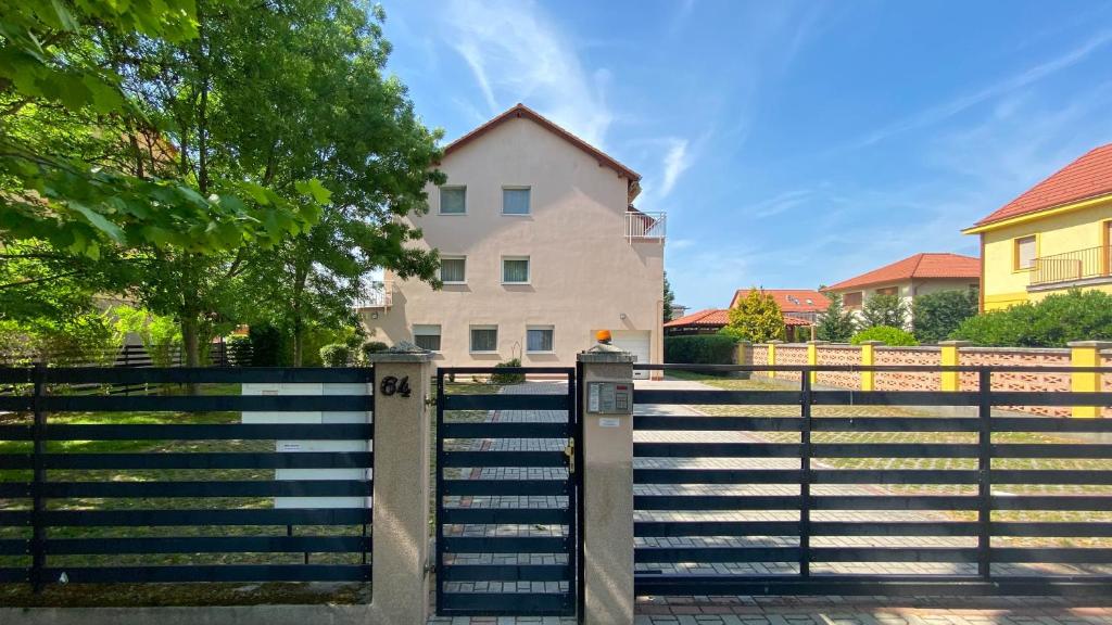 um portão em frente a uma casa com uma cerca em Aranypart Apartman em Siófok