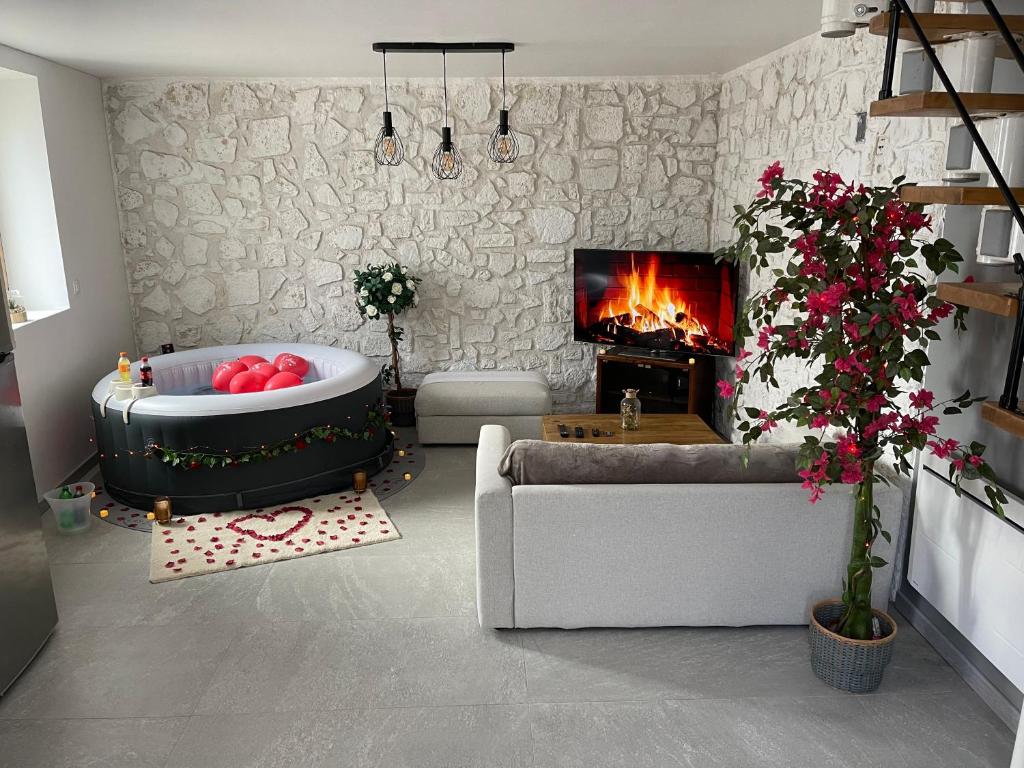 ein Wohnzimmer mit einer Badewanne und einem Kamin in der Unterkunft La maison jacuzzi - Privatiser une soirée jacuzzi in Mandres-les-Roses