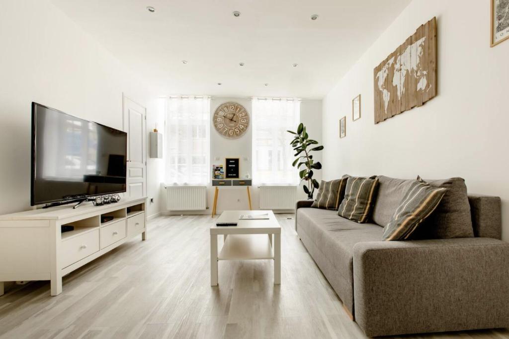sala de estar con sofá y TV de pantalla plana en #Sinetta# Agréable et Spacieux, en Gravelines