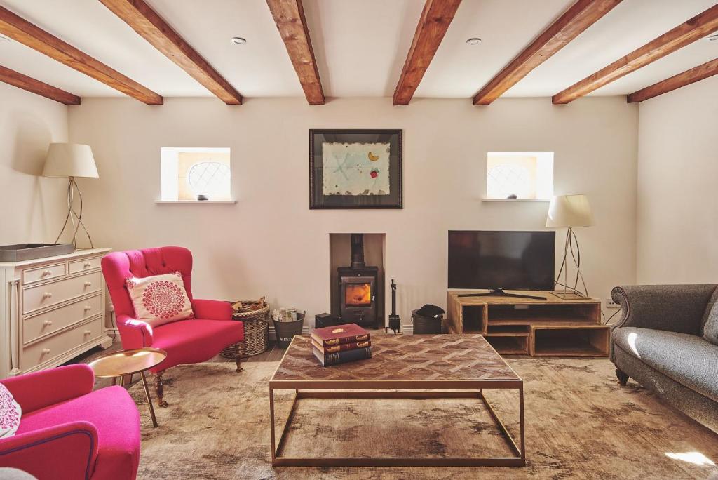 a living room with a couch and a tv at Redwood Cottage in Nantwich