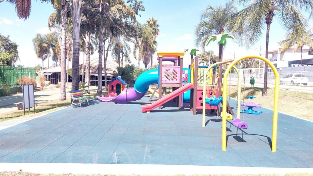 a playground with a slide in a park with palm trees at Apartamento no Jardim botânico in Brasilia