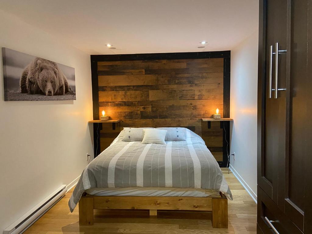 a bedroom with a bed with a wooden accent wall at Condo Hotel Au pied du Mont Orford in Orford