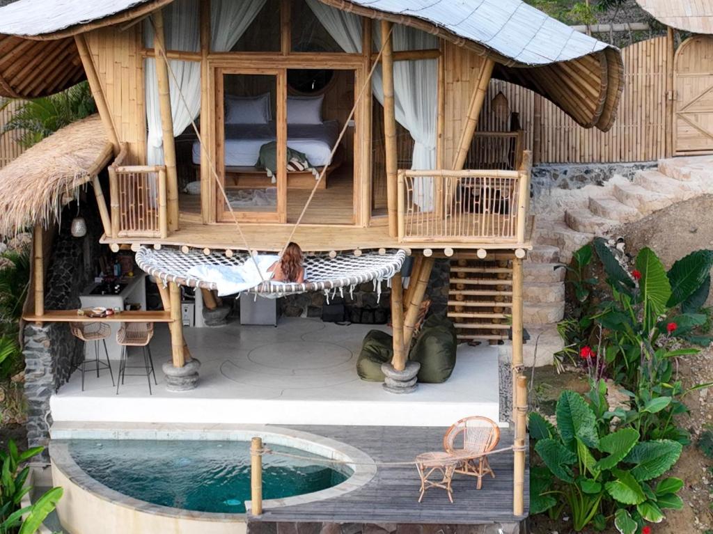 Ein Mann, der in einem Baumhaus auf einer Hängematte liegt in der Unterkunft Kalma Bamboo Eco Lodge in Kuta Lombok