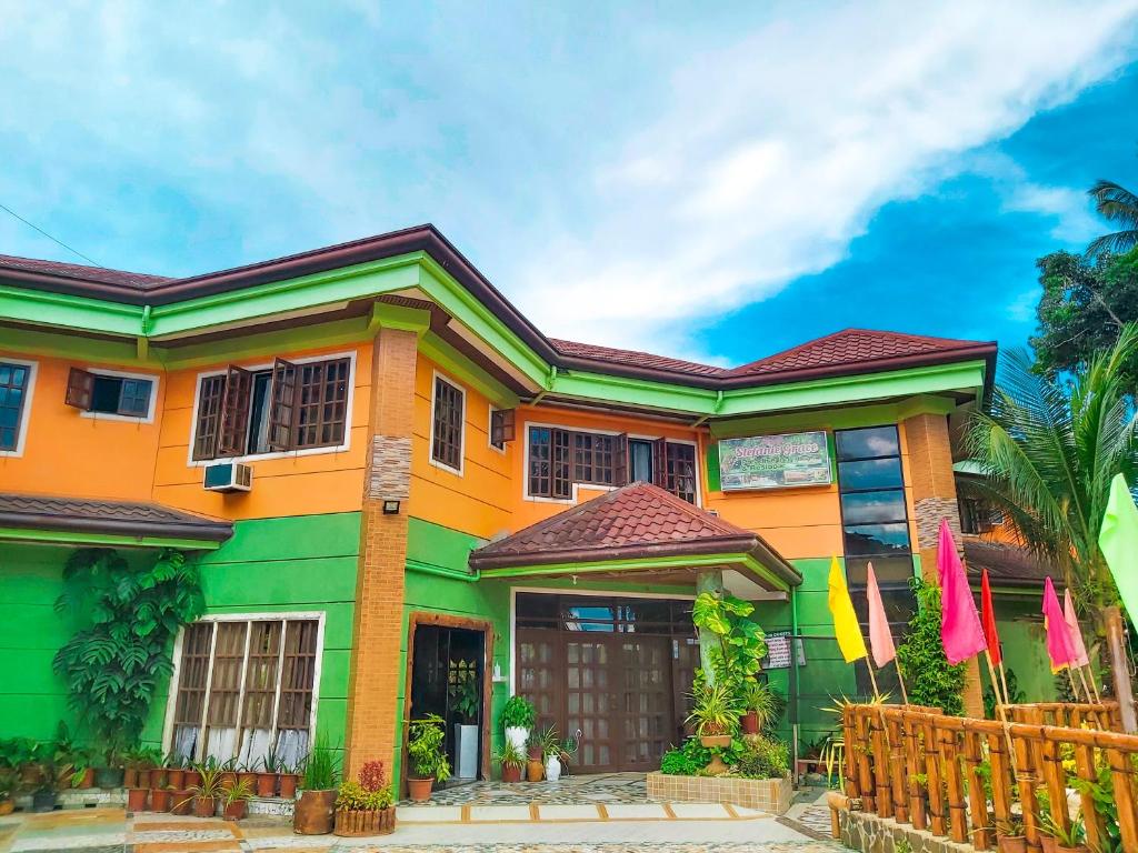 una casa colorata con una recinzione di fronte di Stefanie Grace Paradise Inn a Loboc