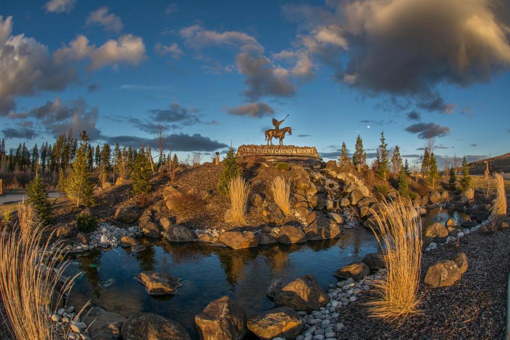 eine Statue eines Hirsches auf einem Hügel neben einem Teich in der Unterkunft Coeur D'Alene Casino Resort Hotel in Worley