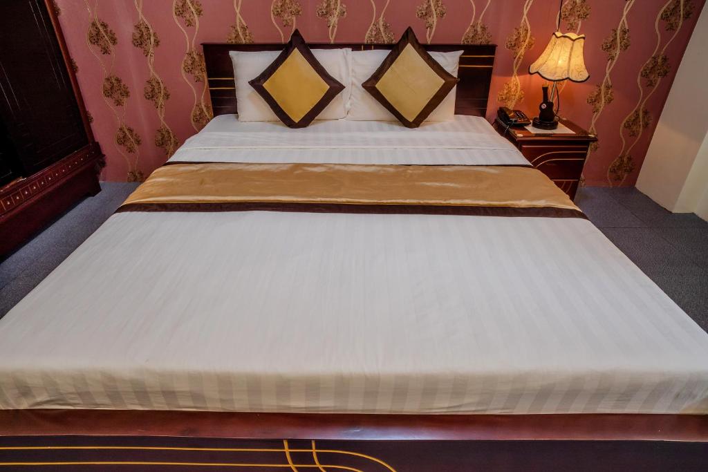a bedroom with a large white bed in a room at Dong Bao Hotel in Chau Doc