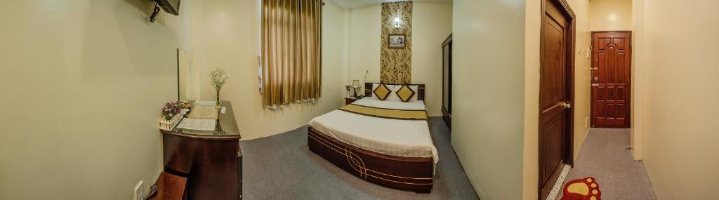 a small room with a bed and a hallway at Dong Bao Hotel in Chau Doc