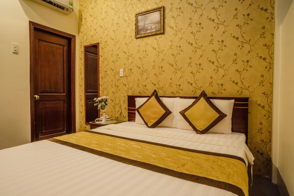 a bedroom with a large bed with yellow wallpaper at Dong Bao Hotel in Chau Doc