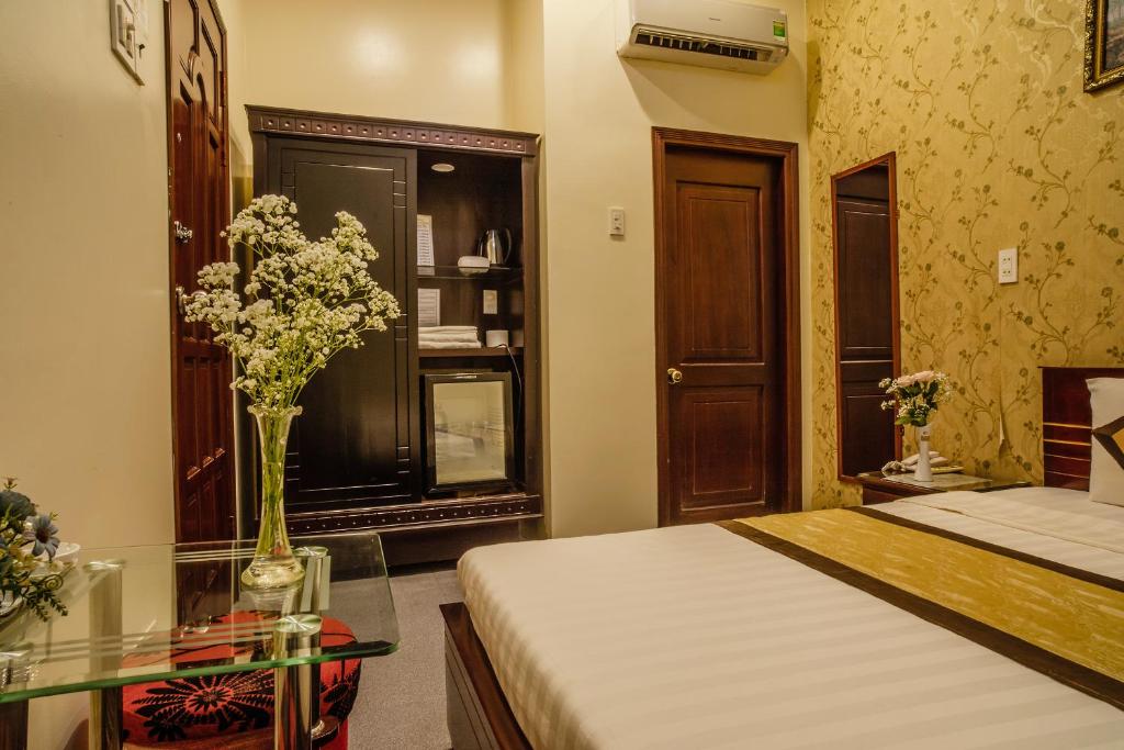 a bedroom with a bed and a vase of flowers at Dong Bao Hotel in Chau Doc