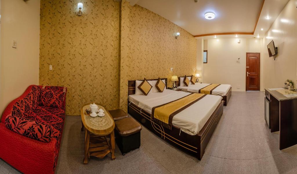 a hotel room with two beds and a chair at Dong Bao Hotel in Chau Doc