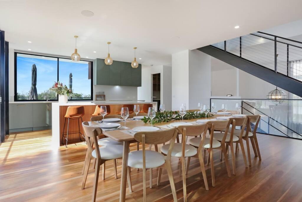 a kitchen and dining room with a table and chairs at Beachfront Escape - 6 bedroom, Pool & beach access in Merimbula