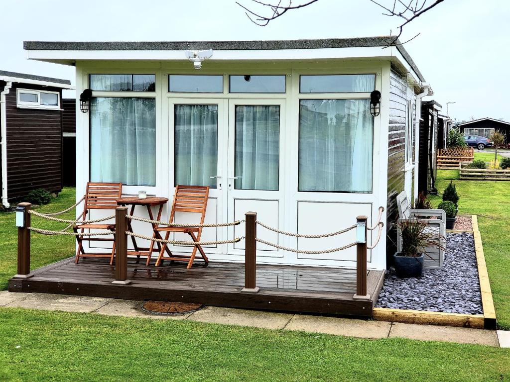 a screened in porch with two chairs and a table at Holiday Chalet no289 in Withernsea