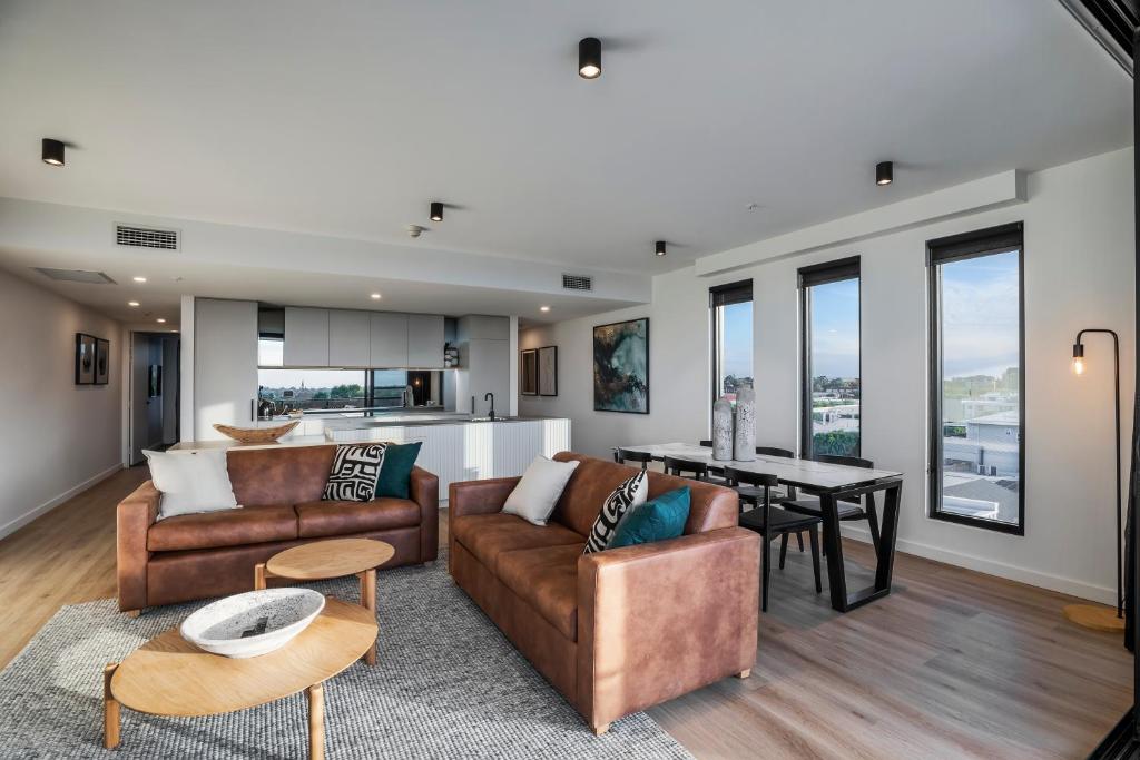 a living room with two couches and a table at KT Apartments in Adelaide