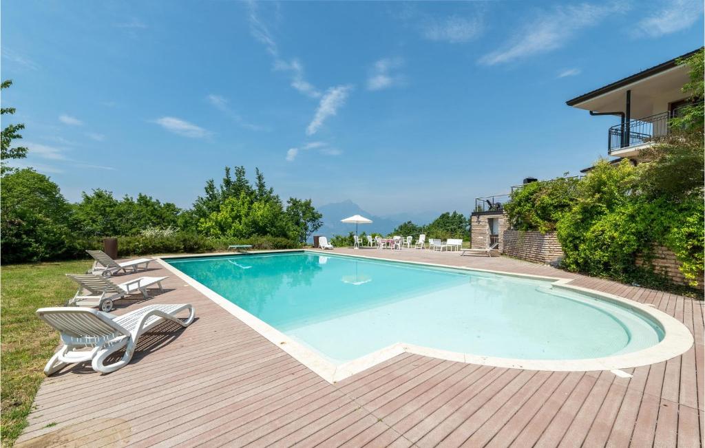 a large swimming pool on a wooden deck with chairs around it at Nice Home In Albisano With Sauna in Albisano