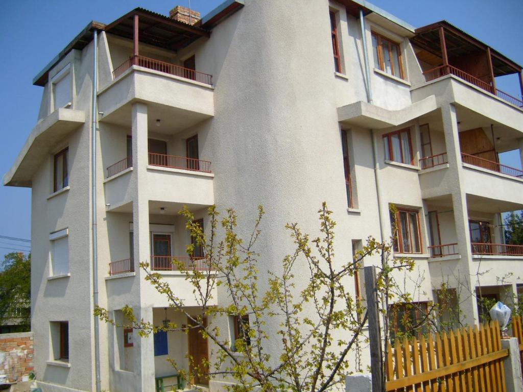 - un bâtiment blanc avec des balcons rouges dans l'établissement Сотирови, самостоятелни стаи, à Tchernomorets