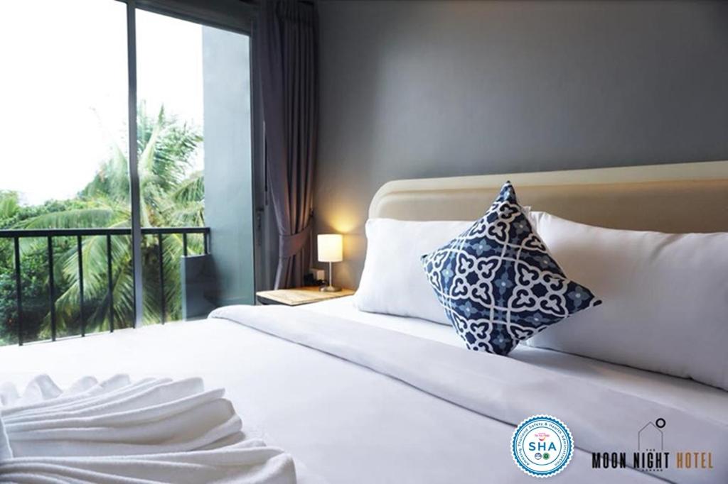 1 dormitorio con cama con almohada y ventana en The Moon Night Ao Nang Hotel, en Ao Nang Beach