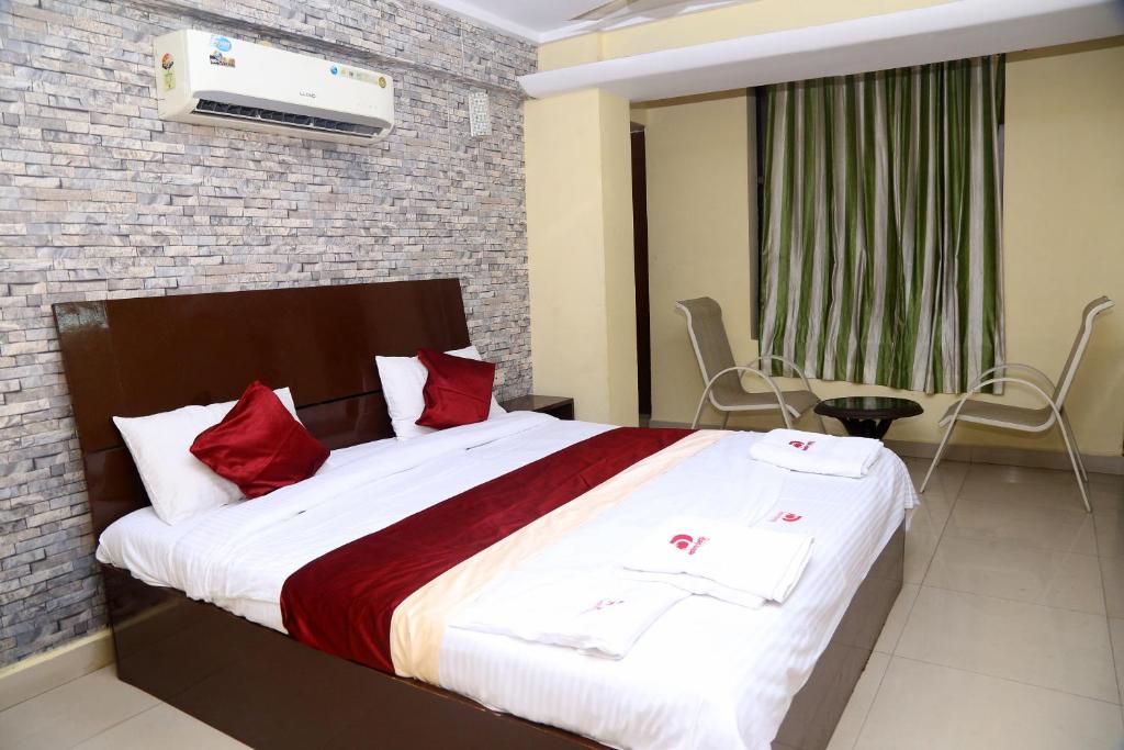 a bedroom with a large bed with red pillows at Hotel Destiny Delight in Visakhapatnam