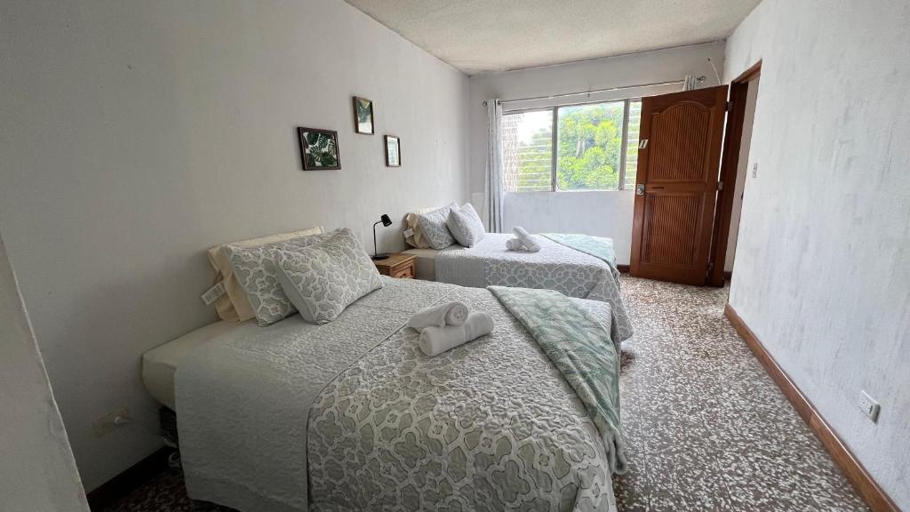 a bedroom with two beds and a window at CASA AZALEA in Guatemala