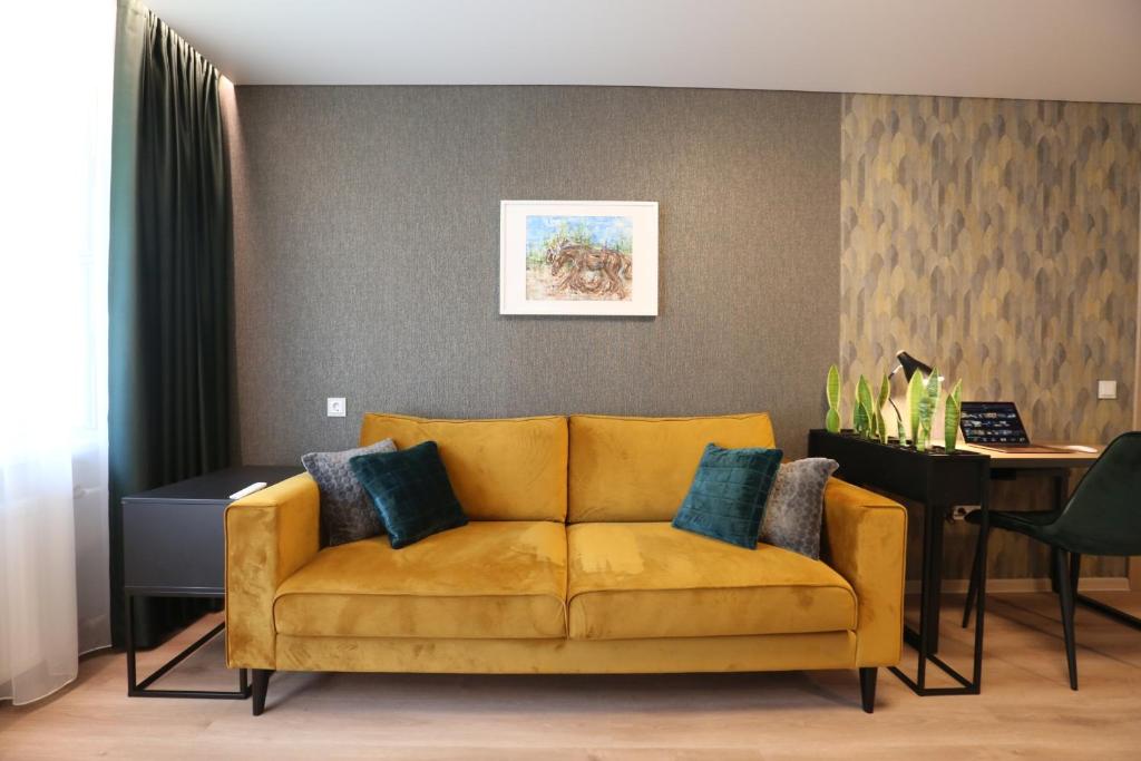 a living room with a yellow couch and a desk at Modern 2 Room Apartment - FREE PARKING - NETFLIX in Alytus