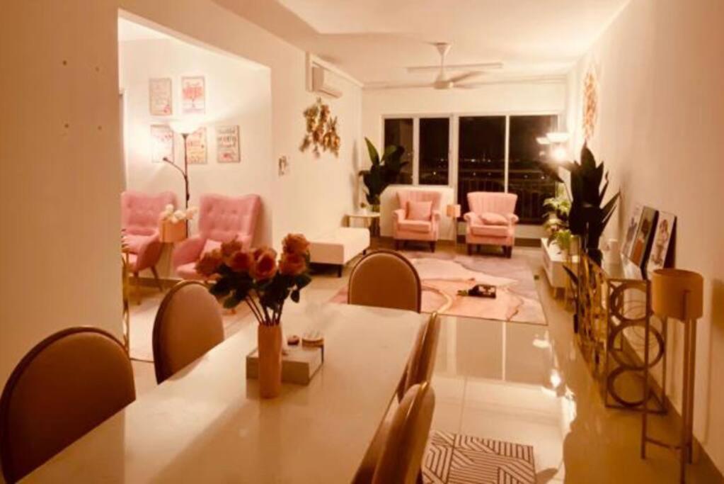 a living room with a long table and chairs at Sentrovue B Pink House in Bandar Puncak Alam