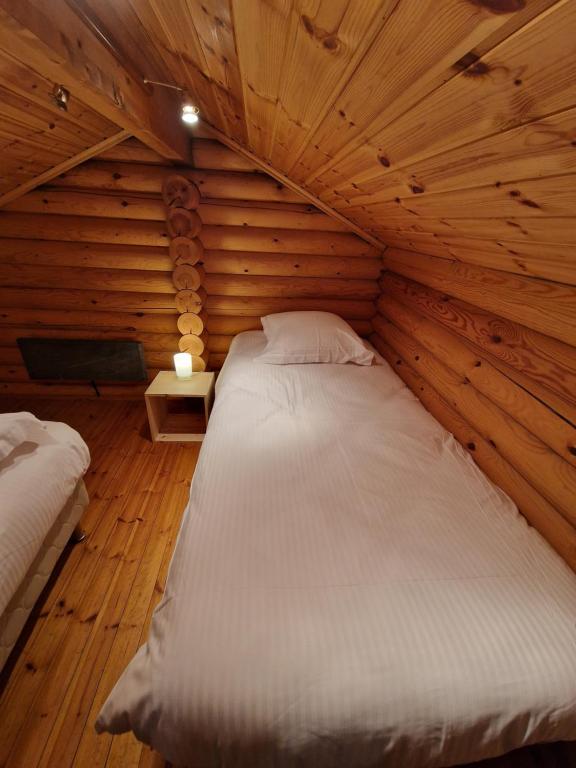 a bedroom with a bed in a wooden room at Les Chalets Amneville in Amnéville