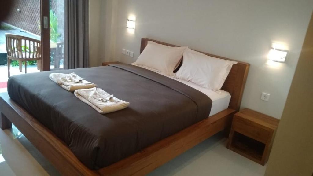 a bedroom with a bed with two towels on it at 21REDA Cozy Stay in Uluwatu