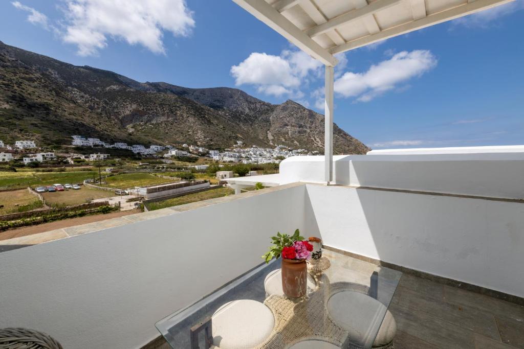 a balcony with a table and chairs and mountains at Villa Areto in Kamares