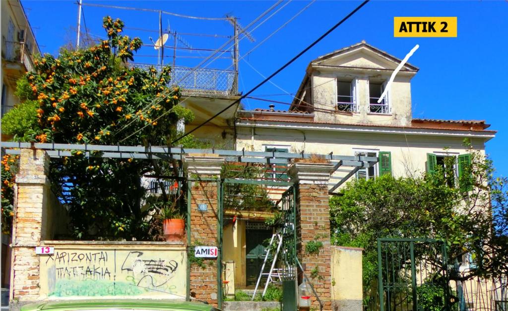 una casa vieja con graffiti a un lado. en Ami's House only for WOMEN dormer, en Corfú